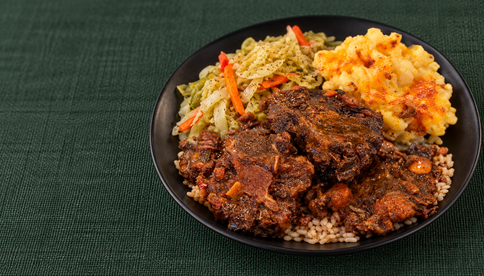 Oxies oxtails with rice and peas, baked mac and cheese, and cabbage